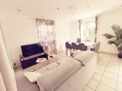 ein Wohnzimmer mit einem weißen Sofa und einem Tisch in der Unterkunft Maison Time Break Jacuzzi - 4 étoiles in Thonon-les-Bains