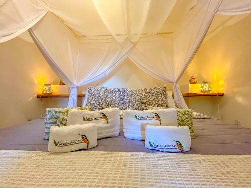 een kamer met een bed in een tent met kussens bij Locanda Ariramba in Santa Cruz Cabrália