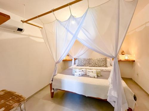 a bedroom with a bed with a mosquito net at Locanda Ariramba in Santa Cruz Cabrália