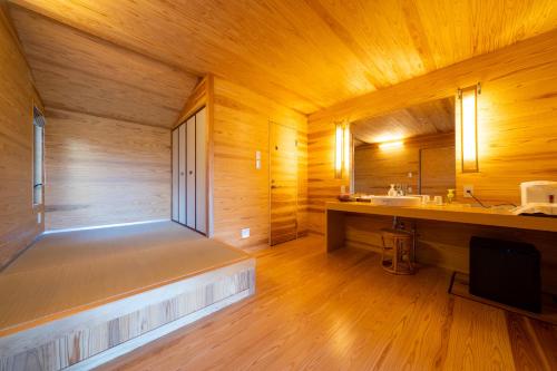 a large wooden room with a tub and a sink at Spagreenness in Kokonoe