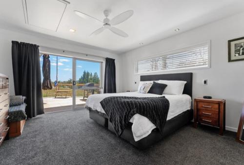 a bedroom with a bed and a ceiling fan at Tauranga Luxury Getaway in Tauranga