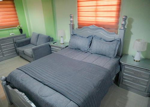 een slaapkamer met een groot bed en een bank bij Suite in San Pedro De Macoris in San Pedro de Macorís
