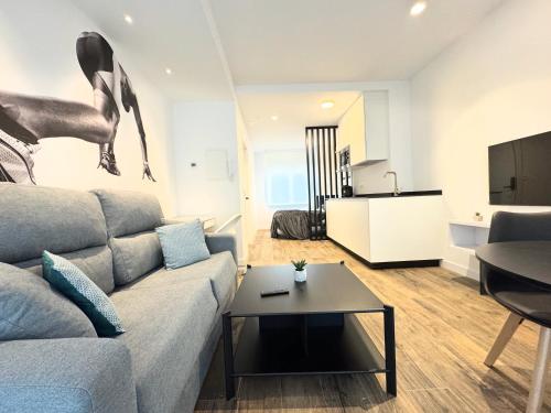 a living room with a couch and a table at Apartamentos Identia Sport by gaiarooms in León