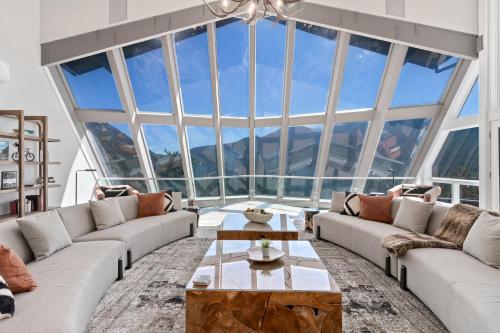 a living room with couches and a large window at Casa de Cristal-Epic Views-HotTub-Sauna-Sleeps 10-Luxury Linens-Stocked Kitchen in Estes Park