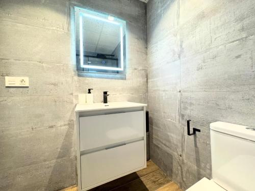 a bathroom with a white sink and a mirror at Apartamentos Identia Sport by gaiarooms in León