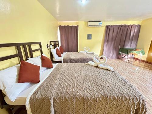 a hotel room with two beds with towels on them at Elegance Guesthouse in Manila