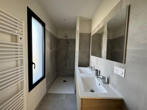 uma casa de banho com um lavatório, um espelho e um chuveiro em Maison Saint-Palais-sur-Mer, 6 pièces, 8 personnes - FR-1-539-61 em Saint-Palais-sur-Mer