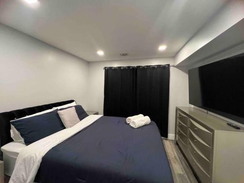 1 dormitorio con 1 cama grande y TV de pantalla plana en The Homey Suite - 1BR with Luxe Amenities, en Paterson