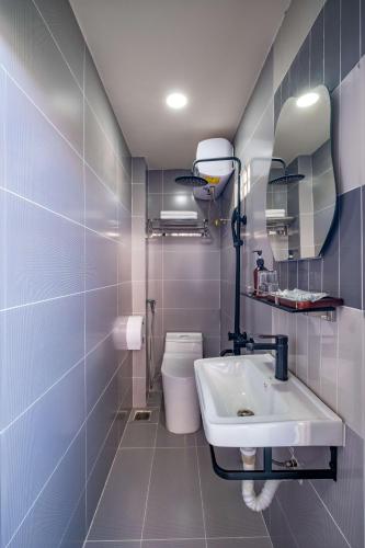 a bathroom with a sink and a toilet and a mirror at Mayy House Dalat in Da Lat