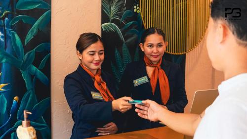 a woman looking at her cell phone in front of a mirror at Lighthouse View Boutique Hotel in Caticlan