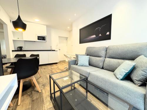 a living room with a couch and a table at Apartamentos Identia Sport by gaiarooms in León