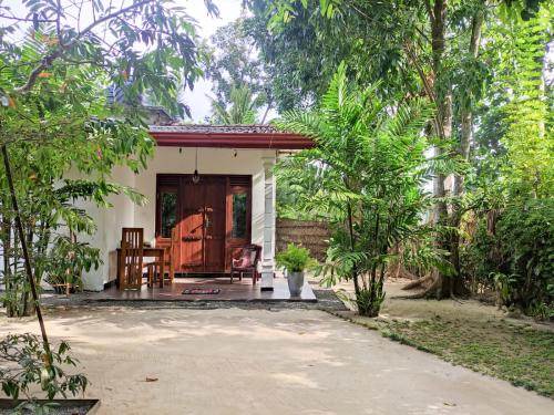 uma pequena casa no meio de um jardim em AURORA Midigama em Ahangama