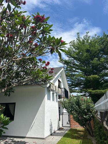 a white house with flowers on the side of it at The Farmhouse in Ipoh