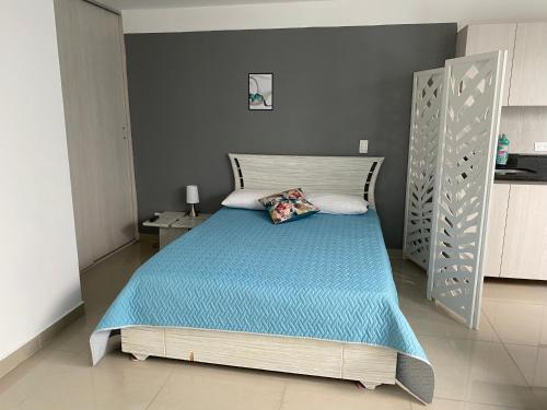 um quarto com uma cama com um edredão azul em Apartamento en envigado em Envigado