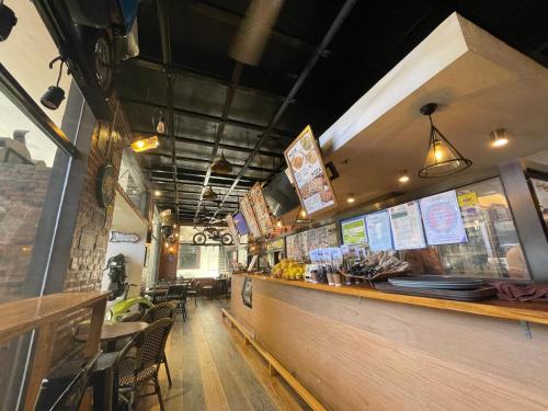 ein Restaurant mit einer Theke mit Tischen und Stühlen in der Unterkunft Casa Marco Suites Puerto Galera powered by Cocotel in Puerto Galera