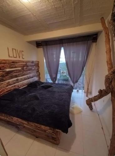 Un dormitorio con una cama grande y una ventana en Vibras Eco Hotel, en Popayán