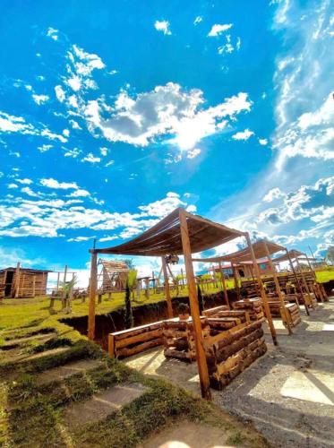 um abrigo de madeira com um céu azul e nuvens em Vibras Eco Hotel em Popayan