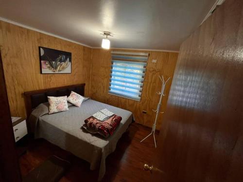 a small bedroom with a bed and a window at Cabañas totalmente equipadas en Valdivia in Valdivia