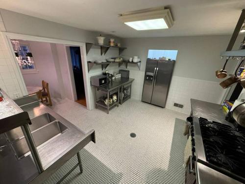 a kitchen with a stainless steel refrigerator in a room at Serene Stay - Stylish House Close to NYC in Paterson