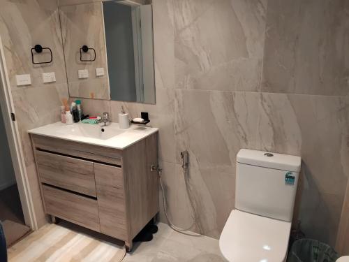 uma casa de banho com um WC branco e um lavatório. em HomeStay! Close to Airport, bus & Train station em Auckland