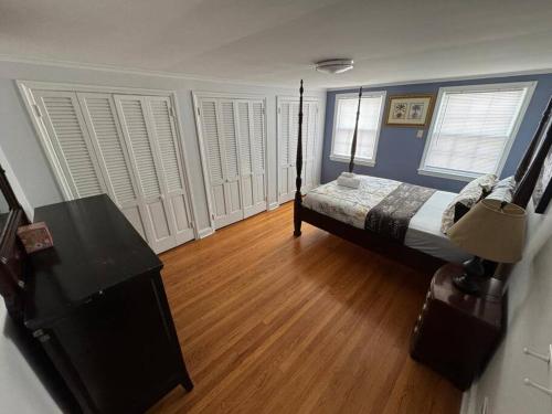 a bedroom with a bed and a wooden floor at Serene Stay - Stylish House Close to NYC in Paterson