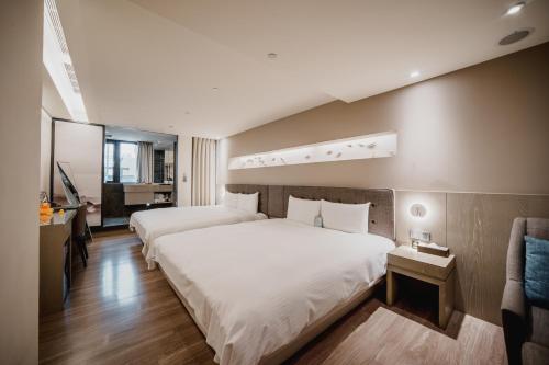 高雄的住宿－旅居文旅 高雄亞灣館，酒店客房设有两张床和电视。