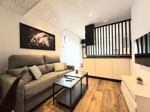a living room with a couch and a table at Apartamentos Identia Sport by gaiarooms in León