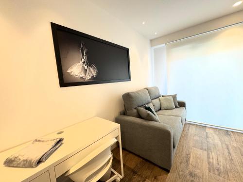 a living room with a couch and a chair at Apartamentos Identia Sport by gaiarooms in León