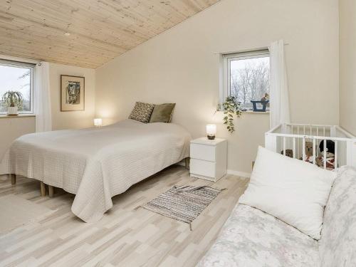 una camera bianca con un letto e un divano di Holiday home Stubbekøbing III a Stubbekøbing