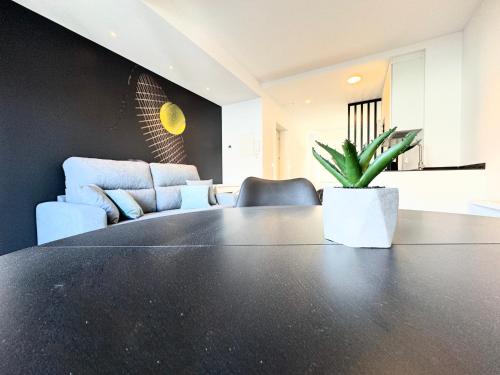 a table with a potted plant in a room at Apartamentos Identia Sport by gaiarooms in León