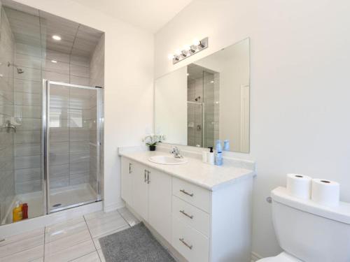une salle de bain blanche avec un lavabo et une douche dans l'établissement Stylish Home in Waterdown, à Hamilton