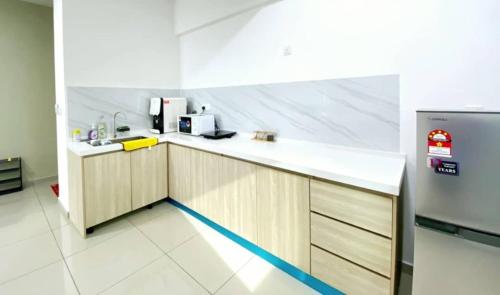 a kitchen with a counter and a refrigerator at JOVIAL Modern Cozy Suite `Metropol BM BandarPerda in Bukit Mertajam
