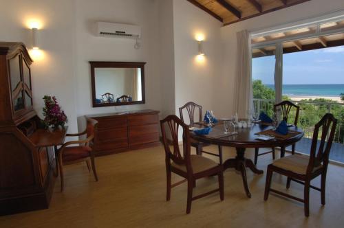 a dining room with a table and chairs and a mirror at Pigeon Island Beach Resort and Spa in Nilaveli