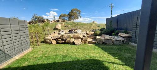 a garden with rocks and a table on a hill at Luxury 5 Bedroom Home - Sentinel Chalet - Snowy Mountains - Jindabyne in Jindabyne