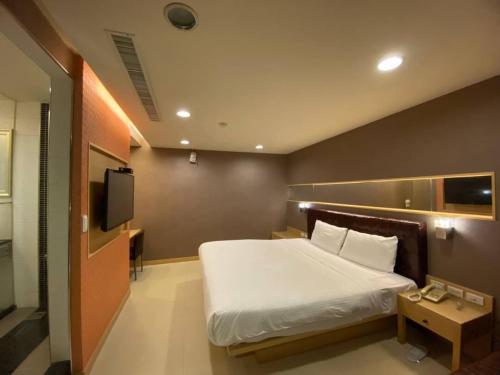 a bedroom with a large bed and a tv at Love Hotel in Pingtung City