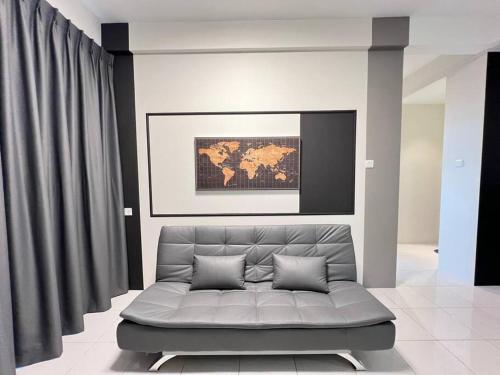 a couch in a living room with a picture on the wall at AJ Homestay Near Kuching Airport in Kuching