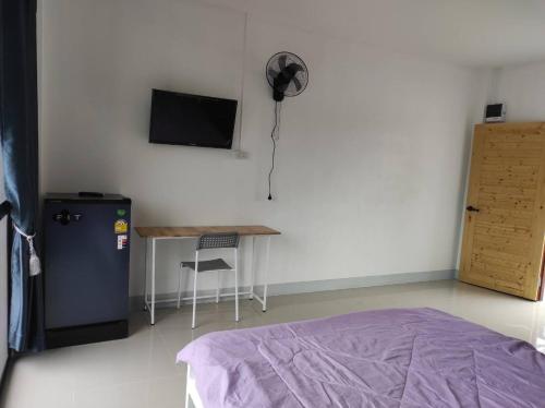 a bedroom with a bed and a desk and a television at Flourish Homes ฟลอริชโฮมส์ ห้องพัก มอเกษตร สกลนคร in Ban Na Oi