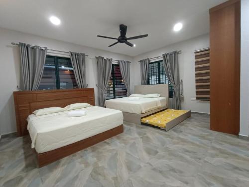 een slaapkamer met 2 bedden en een plafondventilator bij Lubuk Private Villa Langkawi with Jacuzzi Pool in Kuah