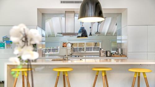a kitchen with yellow stools at a counter at Mi Casa - Patonga Beach My House in Patonga