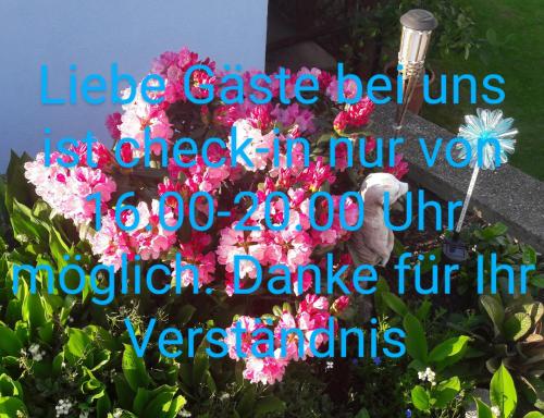 a sign for a garden with pink flowers at Privatzimmer Roland in Hutten