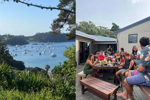 a group of people sitting at a table overlooking a lake at Waiheke Backpackers Hostel in Onetangi