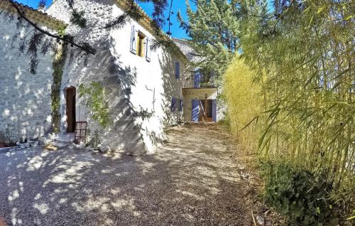 - une vue sur l'extérieur d'un bâtiment blanc avec des arbres dans l'établissement Le Mas Veissiere, à Lussan