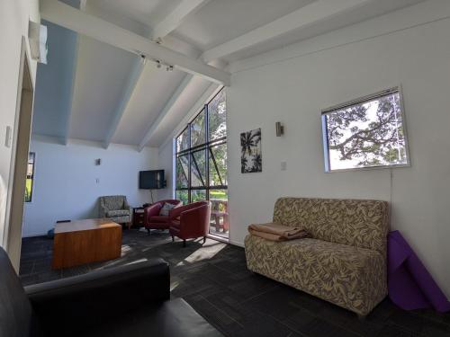 uma sala de estar com um sofá e cadeiras em Waiheke Backpackers Hostel em Onetangi