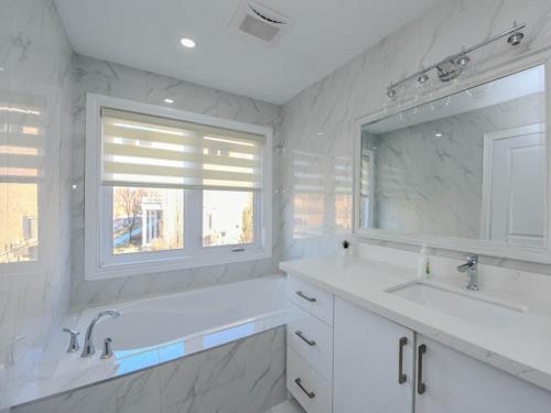 a bathroom with two sinks and a tub and a window at Elegant 5BDR in Mississauga, Brampton, Toronto in Mississauga