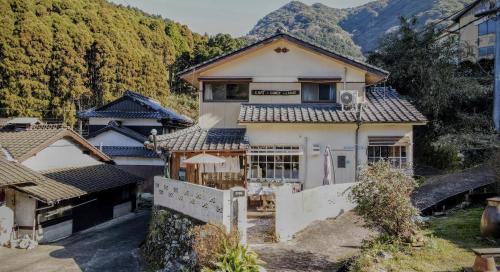 an image of a house with mountains in the background at Okawachiyama LODGE - Village of the Secret Kilns! in Imari