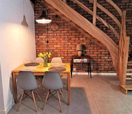 uma sala de jantar com uma mesa de madeira e cadeiras em Chwila Moment - apartament lub cały dom w górach em Stronie Śląskie