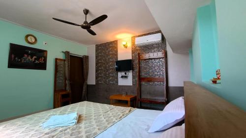 sypialnia z łóżkiem i wentylatorem sufitowym w obiekcie Vishnu Niwas Homestay - Weekend Holiday Home w mieście Abu