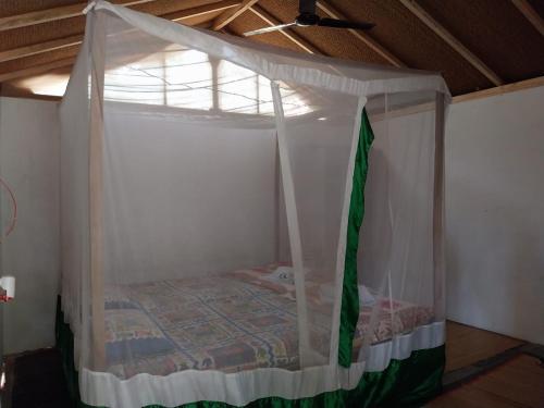 un letto in una camera con baldacchino di Ruban Yoga Palolem a Palolem