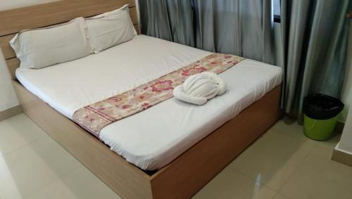 Una cama con una toalla blanca encima. en The Lodge- Bed and Breakfast Hotel en Thiruvananthapuram