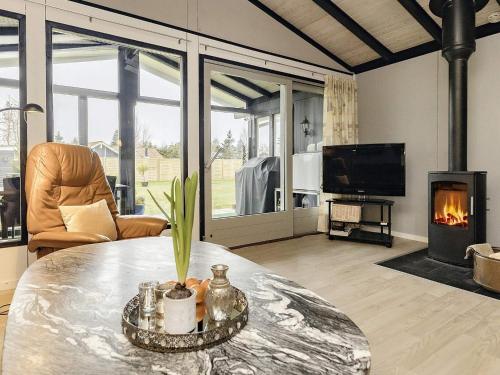 a living room with a table and a fireplace at 4 star holiday home in Væggerløse-By Traum in Bøtø By